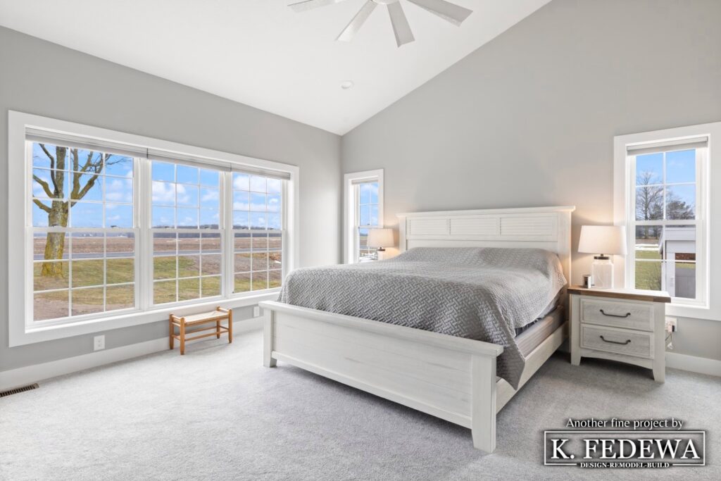 Bedroom addition with beautiful sunlight coming in through the windows onto a white and grey color scheme