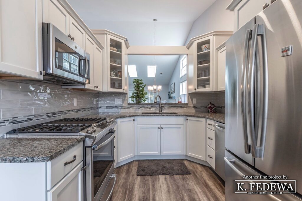 Condo kitchen remodel with white cabinets grey granite countertops and stainless steel appliances