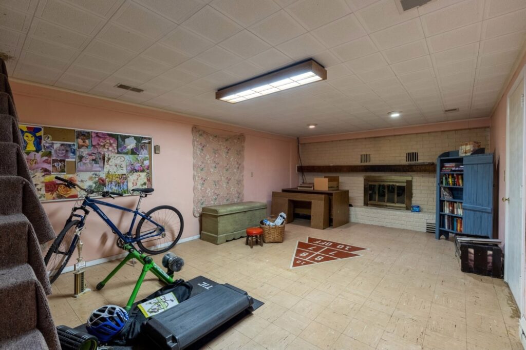Dark basement with furniture and a bike before remodel