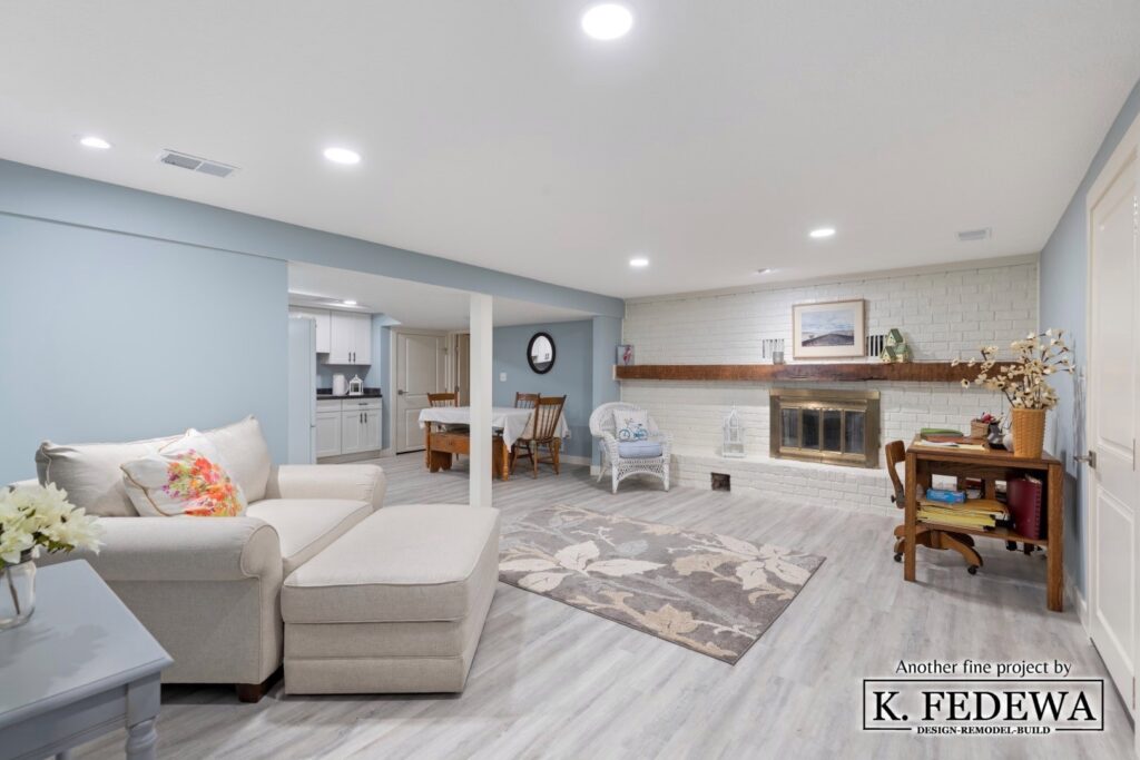 Remodeled basement with grey wood floors blue walls and furniture