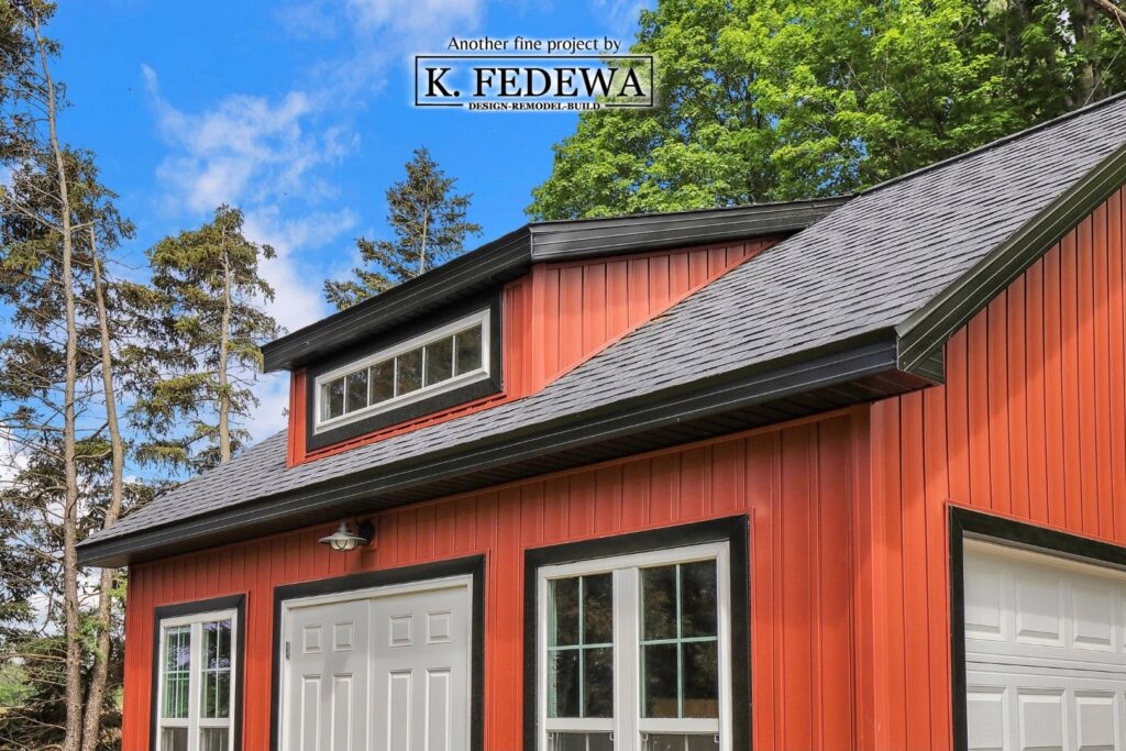 Close-up of loft area on the outside of a red garage with black shingled roof.