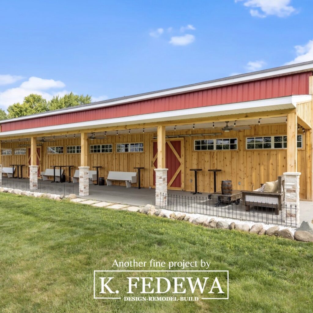 Angled view of stunning wood-trimmed barn-style wedding venue by K. Fedewa Builders.
