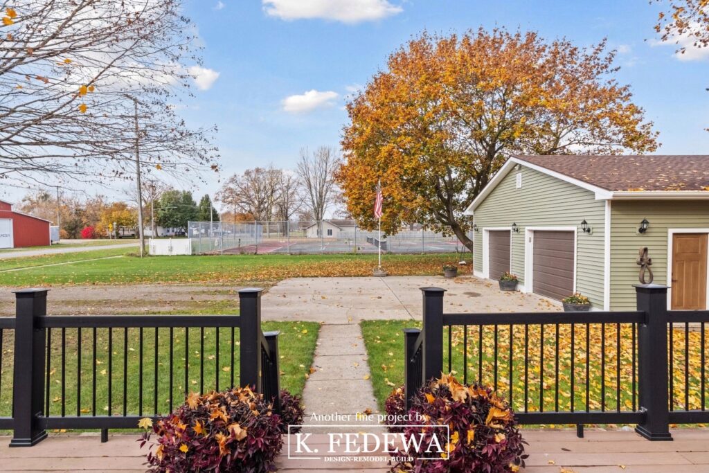 Beautiful Fall view off of a remodeled deck looking out at a large garage with new siding a new roof.