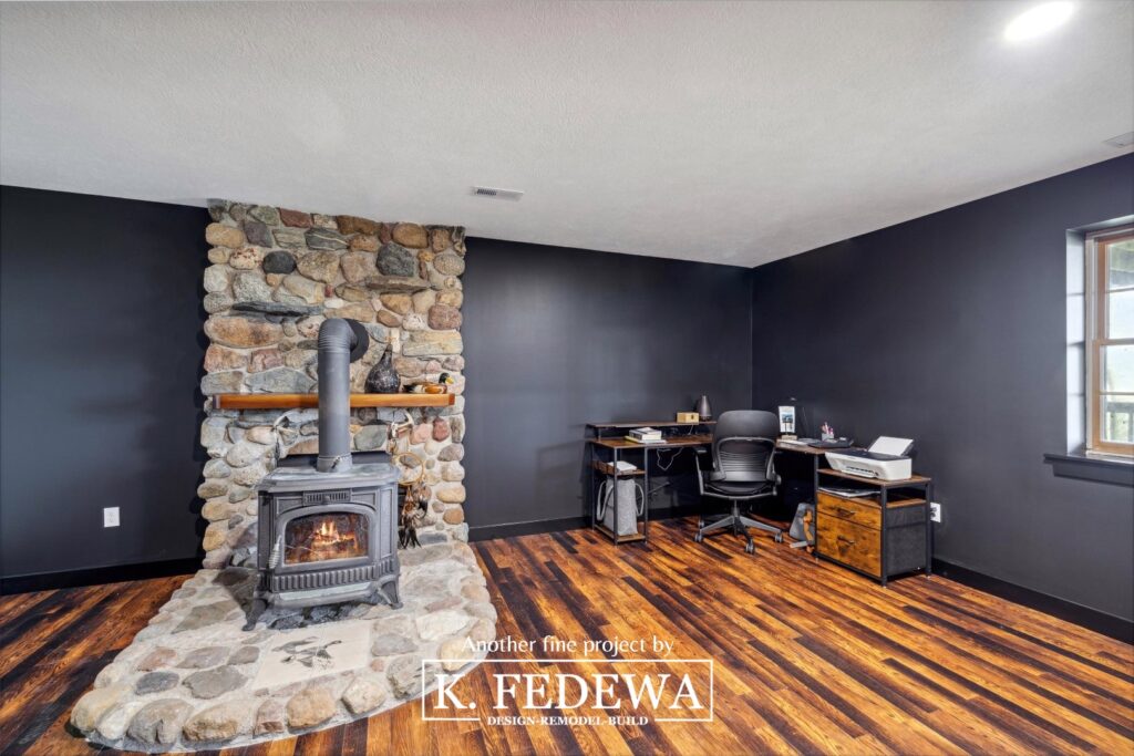 Perrinton, MI finished basement with home office and large cobblestone fireplace.